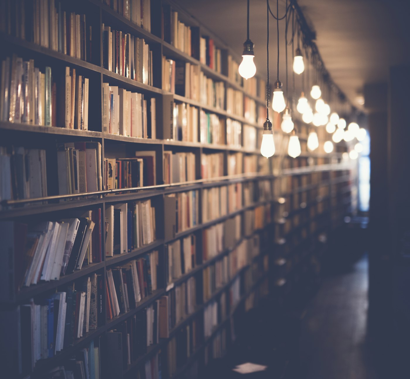 Culoar de bibliotecă cu rafturi de cărți și lumini calde