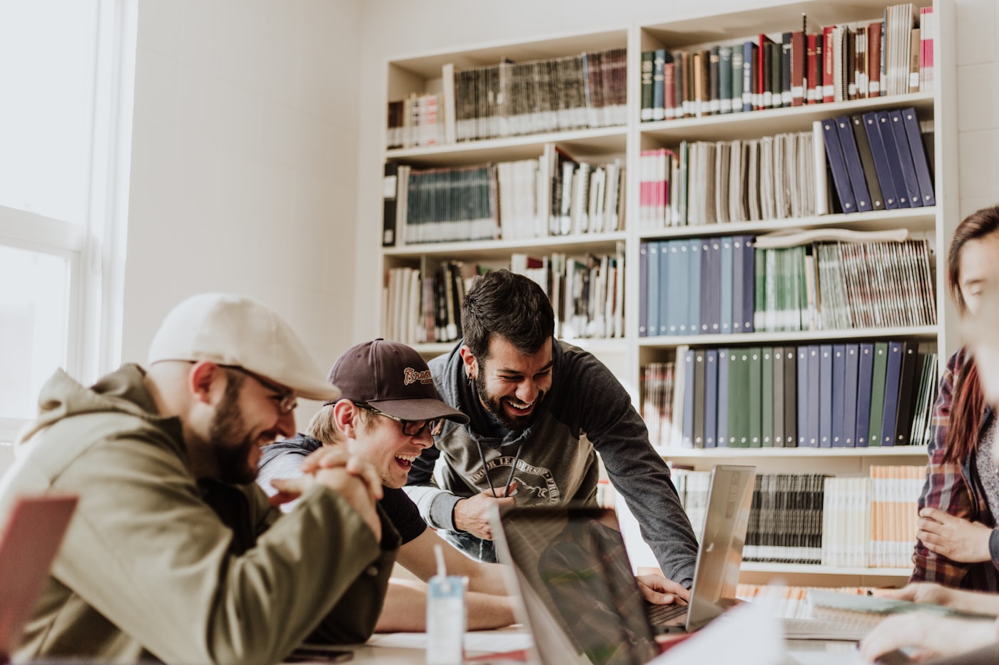 Studenți colaborând într-o bibliotecă universitară